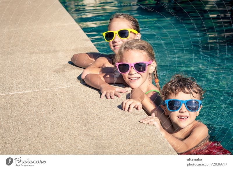 Three happy children playing on the swimming pool Lifestyle Joy Happy Face Relaxation Swimming pool Leisure and hobbies Playing Vacation & Travel Summer Sun