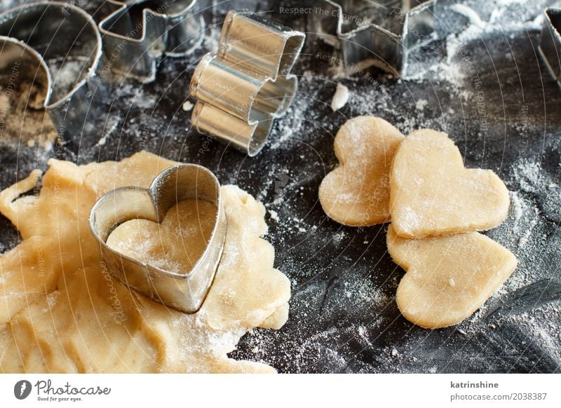 Close up of cookie cutters in a dough on a dark table Dough Baked goods Dessert Kitchen Heart Make Baking Bakery biscuit cooking Cutter Knife Flour food