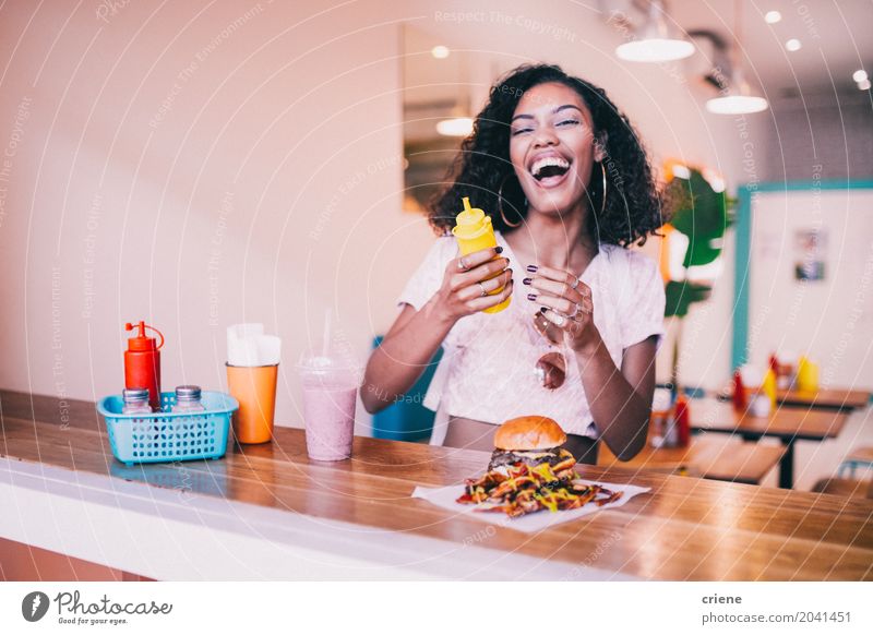 Young happy woman enjoying hamburger and fries in restaurant Roll Eating Lunch Fast food Lifestyle Joy Summer Restaurant Young woman Youth (Young adults)
