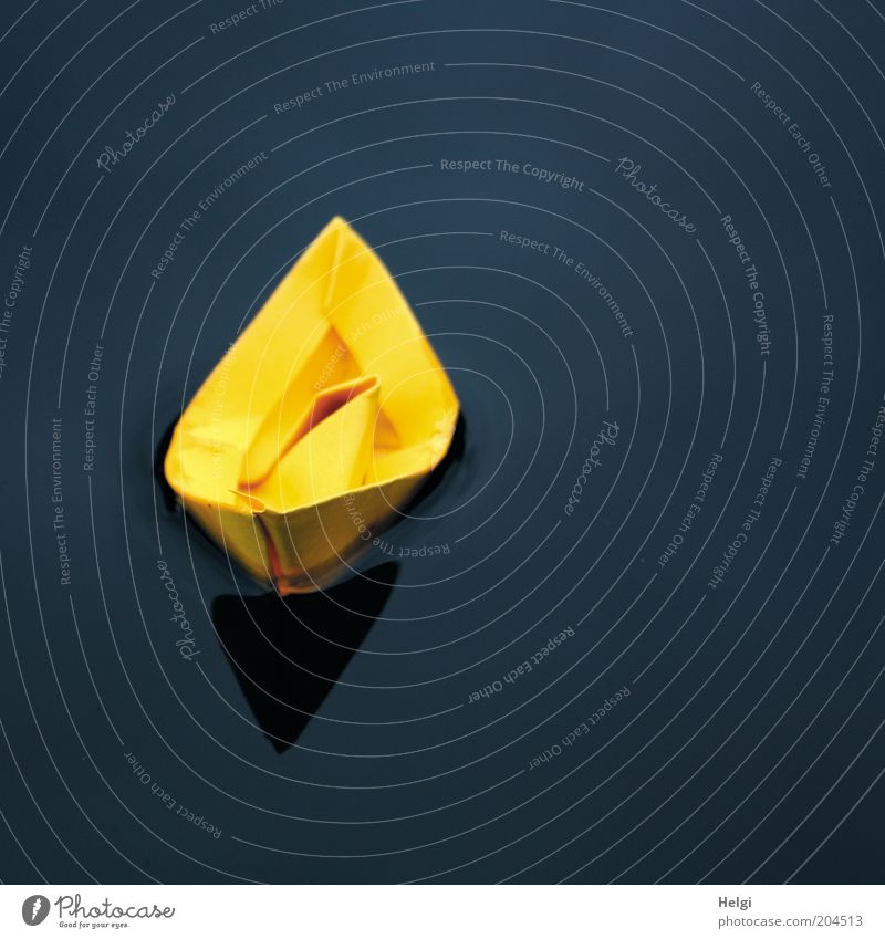 yellow paper boat floating in the water Leisure and hobbies Playing Handicraft Paper Toys Water Esthetic Simple Small Wet Blue Yellow Black Calm Uniqueness