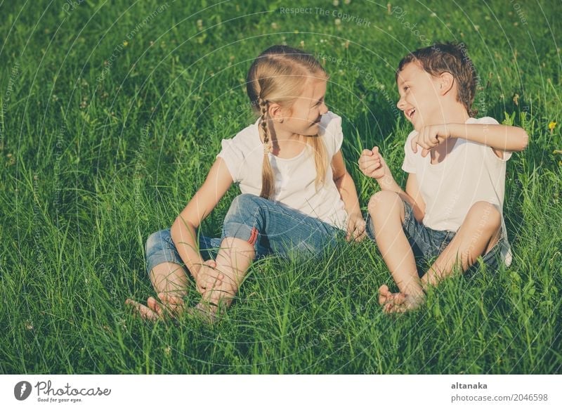 Two happy children playing near a tree on the grass Lifestyle Joy Happy Beautiful Face Leisure and hobbies Playing Vacation & Travel Freedom Summer Child