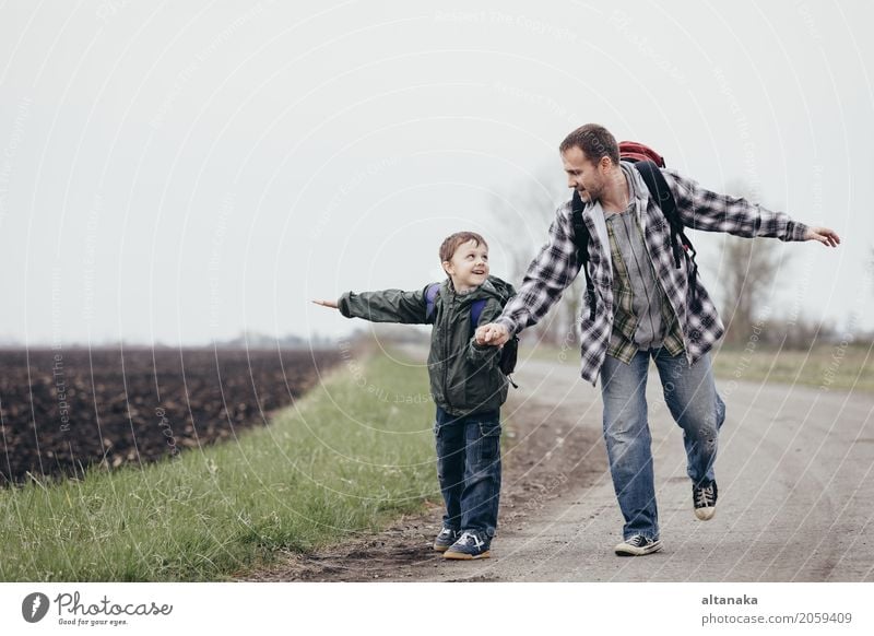 Father and son walking on the road at the day time. People having fun outdoors. Concept of friendly family. Lifestyle Joy Happy Leisure and hobbies