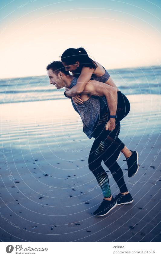 Fit adult couple doing piggyback on beach Lifestyle Joy Personal hygiene Athletic Fitness Beach Ocean Sports Woman Adults Man Couple Partner