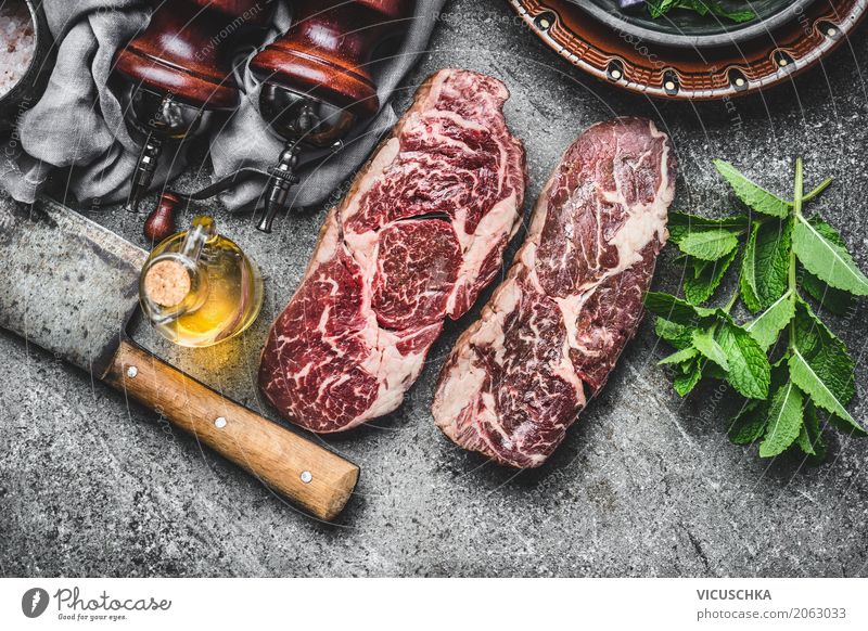 Two marbled raw beef steaks with mincing knife and spices Food Meat Herbs and spices Cooking oil Nutrition Lunch Dinner Picnic Crockery Knives Style Design