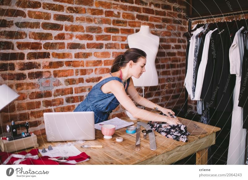 Young female fashion designer working in her studio Lifestyle Handcrafts Desk Work and employment Profession Workplace Office Factory Business SME Notebook