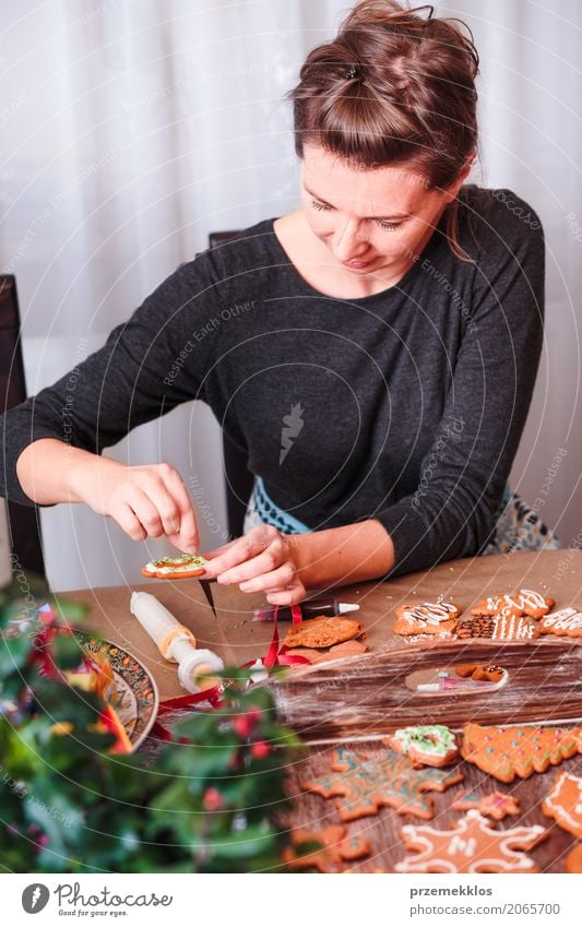 Woman decorating baked Christmas gingerbread with frosting Food Table Kitchen Feasts & Celebrations Christmas & Advent Human being Adults 1 30 - 45 years
