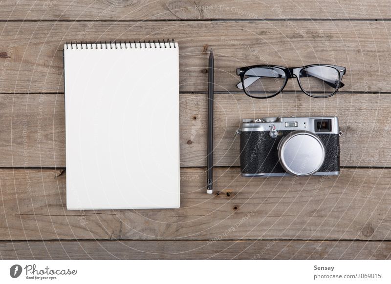 Notepad, glasses and camera on the wooden desk Vacation & Travel Desk Table Workplace Office Business Camera Musical notes Paper Pen Wood Old Cool (slang) Above