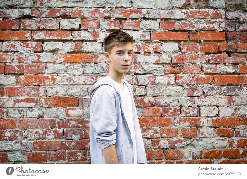 portrait of a cool teenager with hoodie in front of a brick wall Lifestyle Style Contentment Senses Human being Masculine Young man Youth (Young adults) Man