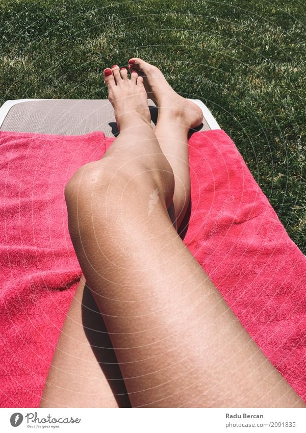 Beautiful Girl Relaxing Her Feet On Pink Towel In Grass - a