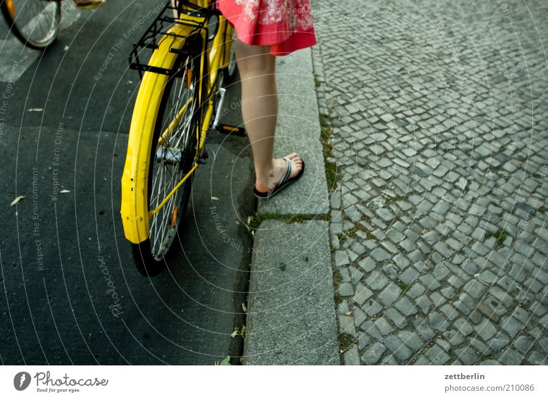 traffic light Human being Woman Adults Legs Feet 1 Driving Stand Wait Bicycle Wheel Guard Spokes Curbside Paving stone Cobblestones Sidewalk Seam Dress Skirt