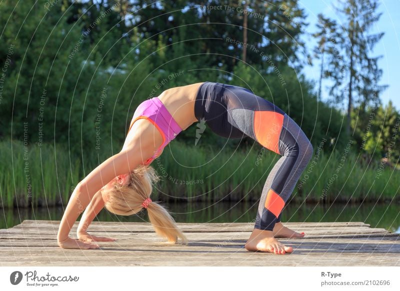 A sporty woman doing yoga and stretching exercises Lifestyle Wellness Harmonious Sports Yoga Human being Woman Adults Nature Park Fashion Blonde Fitness
