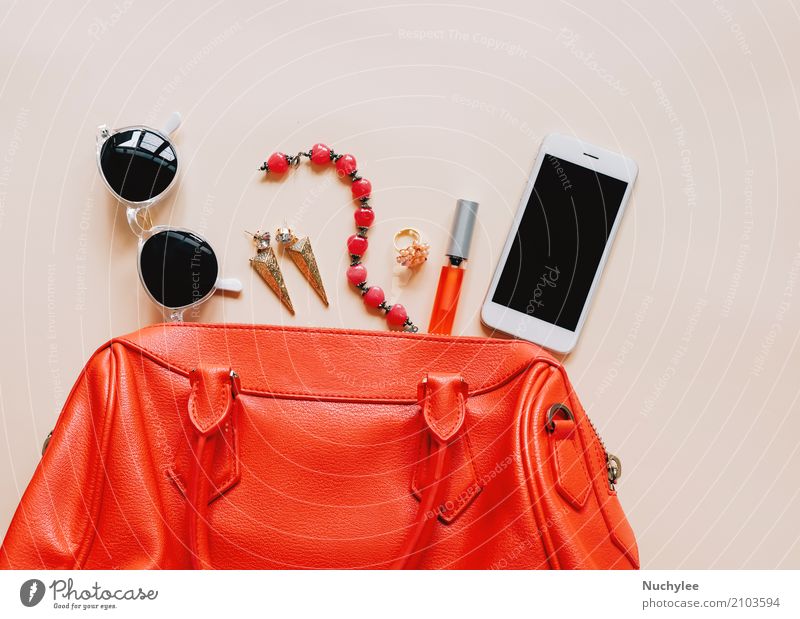 Flat lay of red leather woman bag open out with cosmetics Elegant Style Design Beautiful Make-up Lipstick Vacation & Travel Telephone PDA Technology Feminine