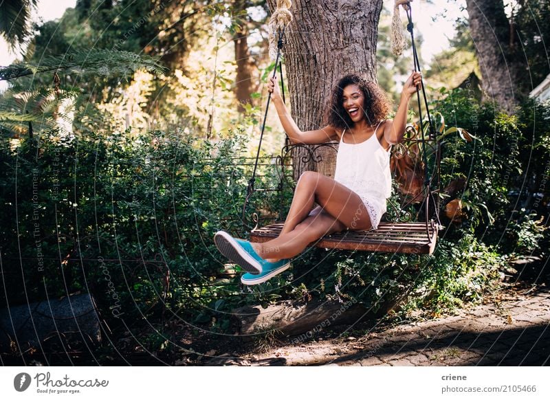 African Woman sitting on swing in the garden in summer Lifestyle Joy Happy Leisure and hobbies Summer Summer vacation Sun Garden Human being Feminine