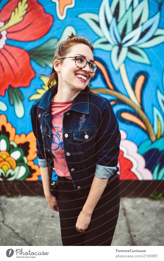 Young attractive woman with glasses and jeans jacket smiling in front of colorful wall Feminine Young woman Youth (Young adults) Woman Adults 1 Human being