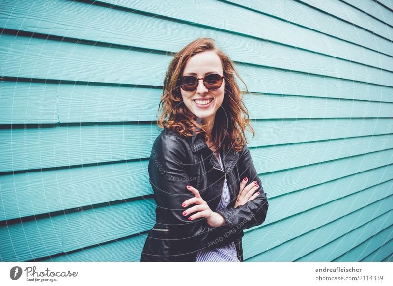 Laughing young woman with sunglasses in front of turquoise wooden facade Lifestyle Vacation & Travel Tourism Trip Far-off places Freedom Sightseeing City trip