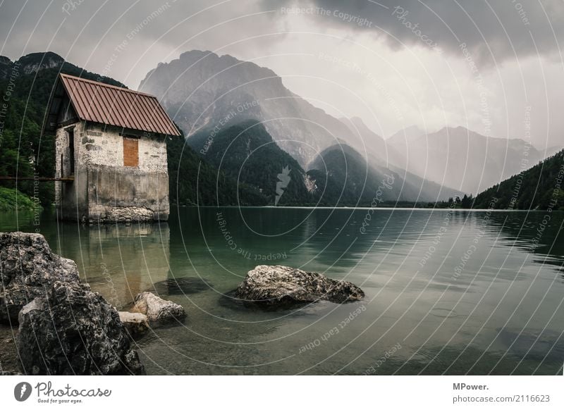 the lake of Ribles Environment Nature Landscape Storm clouds Summer Bad weather Wind Rain Alps Mountain Peak Lake Dark Moody Mountain lake Hut Italy