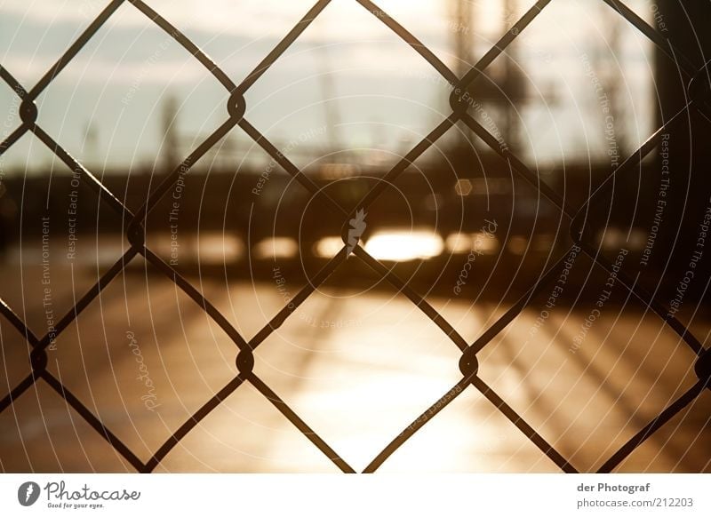 Behind borders Harbour Fence Barrier Colour photo Exterior shot Close-up Deserted Twilight Sunlight Blur Wire netting fence Brownish Border Day