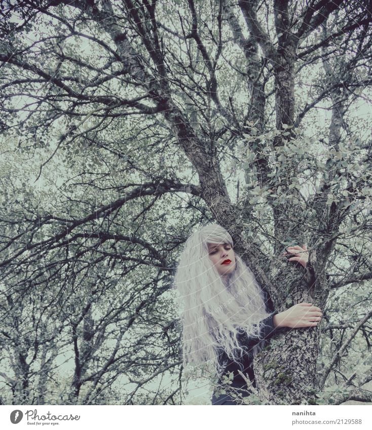 Young woman with white hair is hugging a tree - a Royalty Free