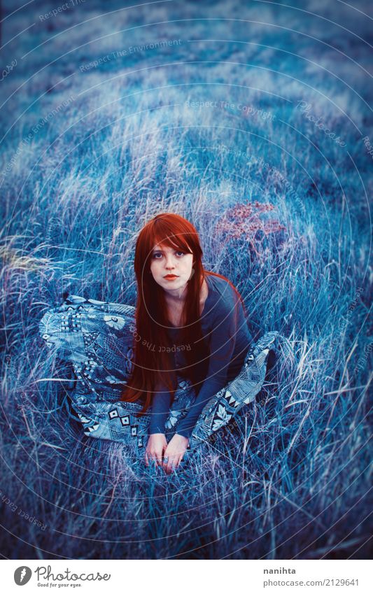 Young redhead woman sitting on a field of blue grass Human being Feminine Young woman Youth (Young adults) 1 18 - 30 years Adults Nature Grass Meadow Field