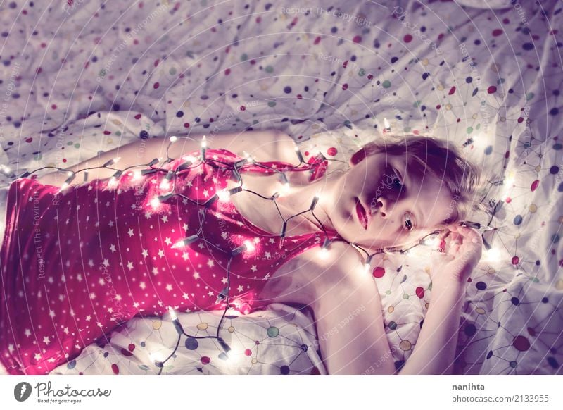 Young woman lying in her bed covered with christmas lights Lifestyle Lamp Bed Bedroom Christmas & Advent New Year's Eve Human being Feminine