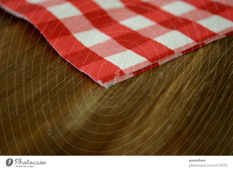 A red and white chequered napkin lies on a wooden table. Gastronomy Style Decoration Napkin Kitsch Brown Red White Checkered Wood grain Structures and shapes