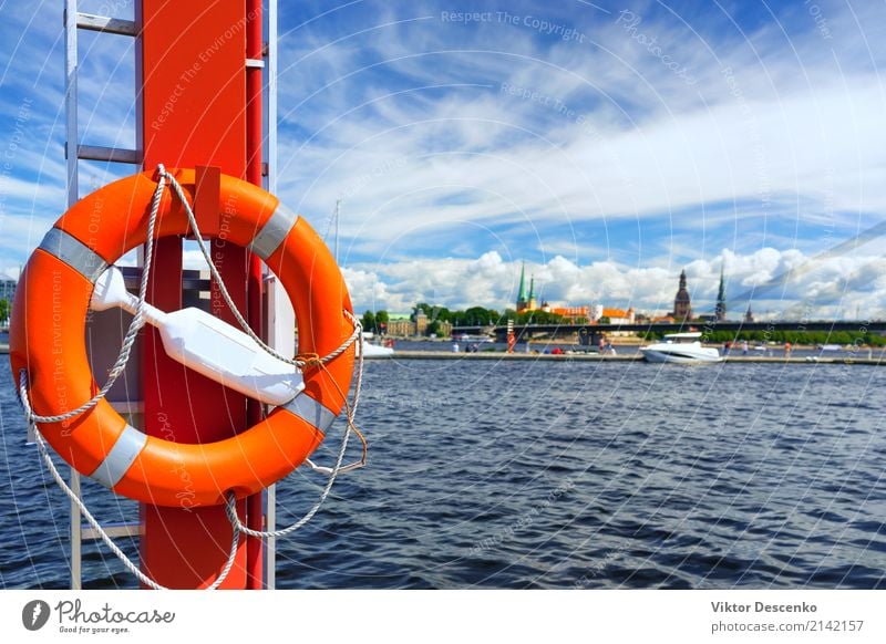 Life ring in the background of the city of Riga Vacation & Travel Tourism Summer Beach Ocean Winter Landscape Coast Harbour Transport Watercraft Ring Blue Red