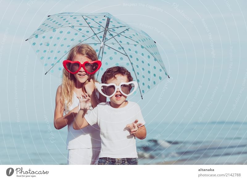 Two happy children standing on the beach at the day time. Concept of friendly family. Lifestyle Joy Happy Beautiful Relaxation Leisure and hobbies Playing