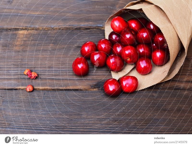 Red cherry in a paper bag Fruit Dessert Eating Vegetarian diet Juice Summer Garden Table Nature Paper Wood Fresh Natural Above Juicy background Berries Cherry