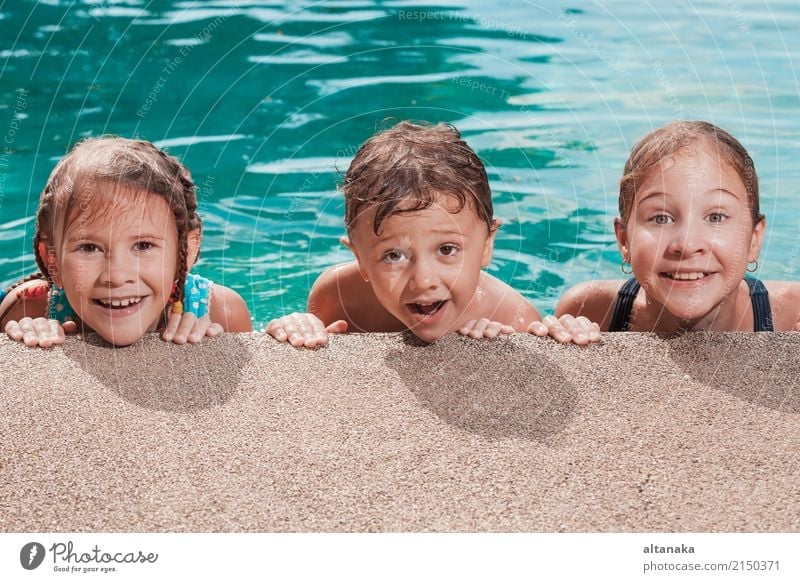Three happy children playing on the swimming pool at the day time. People having fun outdoors. Concept of friendly siblings. Lifestyle Joy Happy Face Relaxation