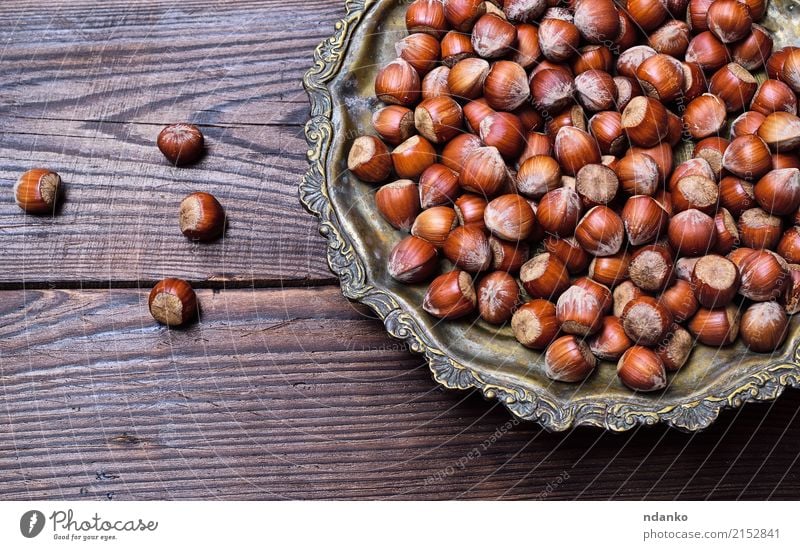 Hazelnuts on an iron plate Fruit Nutrition Vegetarian diet Plate Table Nature Autumn Wood Old Eating Fresh Natural Above Strong Brown background dry eat Edible
