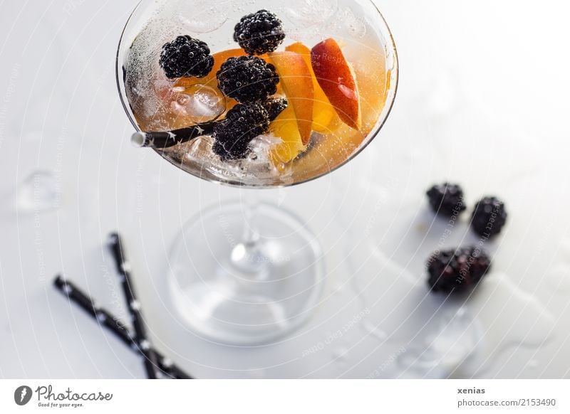 Refreshing drink full of vitamins in a cocktail glass with blackberries, nectarine, ice cubes and drinking straw Beverage Blackberry Nectarine Ice cube