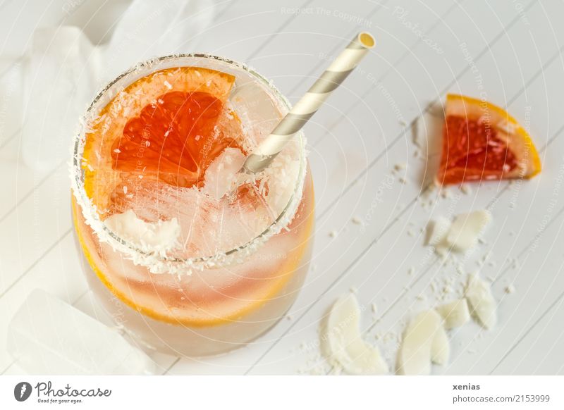 Fresh grapefruit with coconut rasps in water Fruit Grapefruit Coconut Ice cube Organic produce Vegetarian diet Beverage Cold drink Drinking water Lemonade Glass