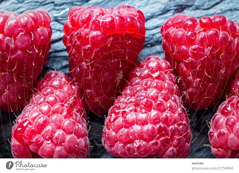 Raspberries lie on slate Fruit Raspberry Organic produce Vegetarian diet Healthy Eating Summer Autumn Fresh Delicious cute Gray Red Vitamin Slate Row