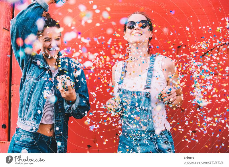 Two happy young adult friends dancing and throwing confetti Lifestyle Joy Feminine Young woman Youth (Young adults) 2 Human being 18 - 30 years Adults Movement