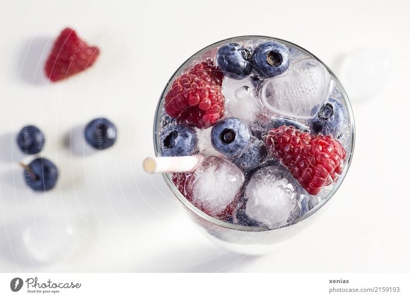 Berry-fruity water, iced with raspberries, blueberries, ice cubes and drinking straw on white background Beverage Cold drink Fruit Raspberry Blueberry Ice cube