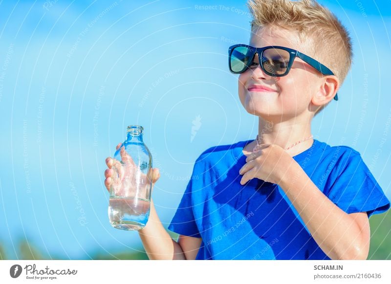 Portrait of a thirsty handsome boy in sunglasses drinking water Cold drink Drinking water Bottle Lifestyle Joy Playing Summer Island Child Boy (child) Man