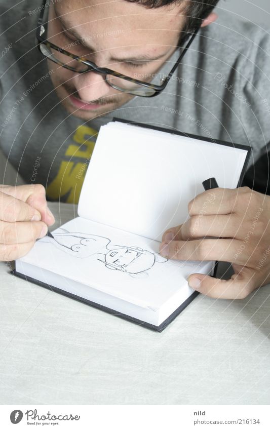 Detail of a hand drawing a manga figure in a sketchbook with a drawing pen  - a Royalty Free Stock Photo from Photocase