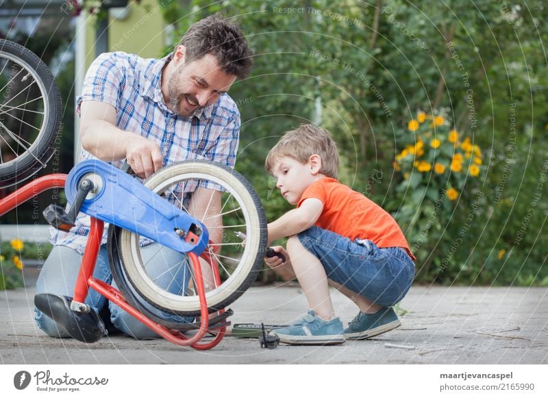 Father and son repair a bicycle together Lifestyle Leisure and hobbies Handicraft Repair Bicycle Garden Human being Masculine Child Boy (child) Man Adults