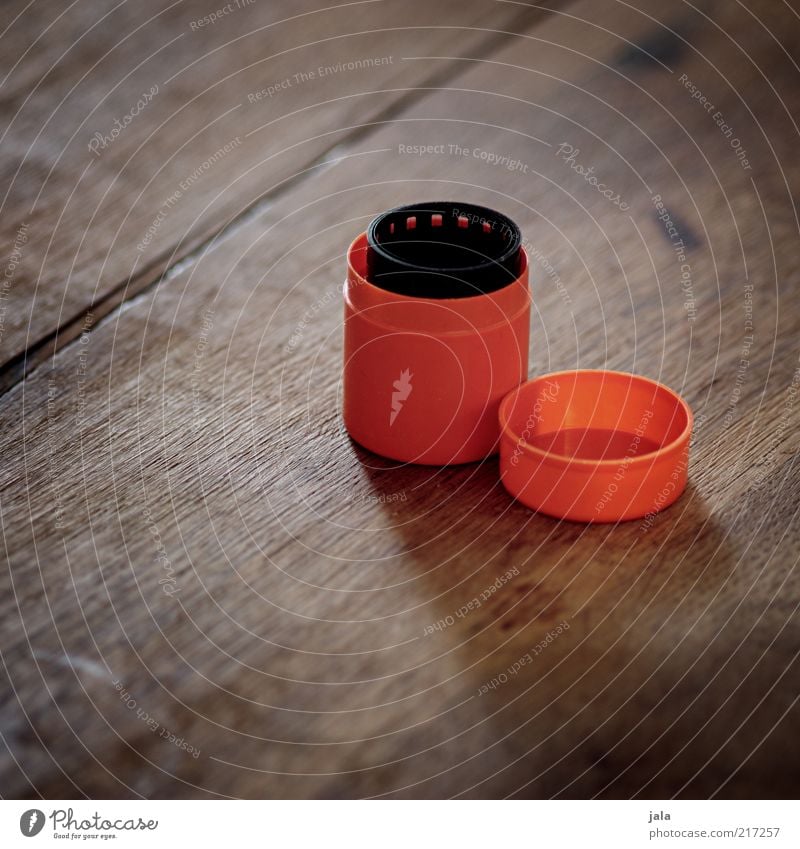 coiled Tin Plastic container Containers and vessels Keep Film industry Negative Wood Brown Black Orange Analog Colour photo Interior shot Deserted