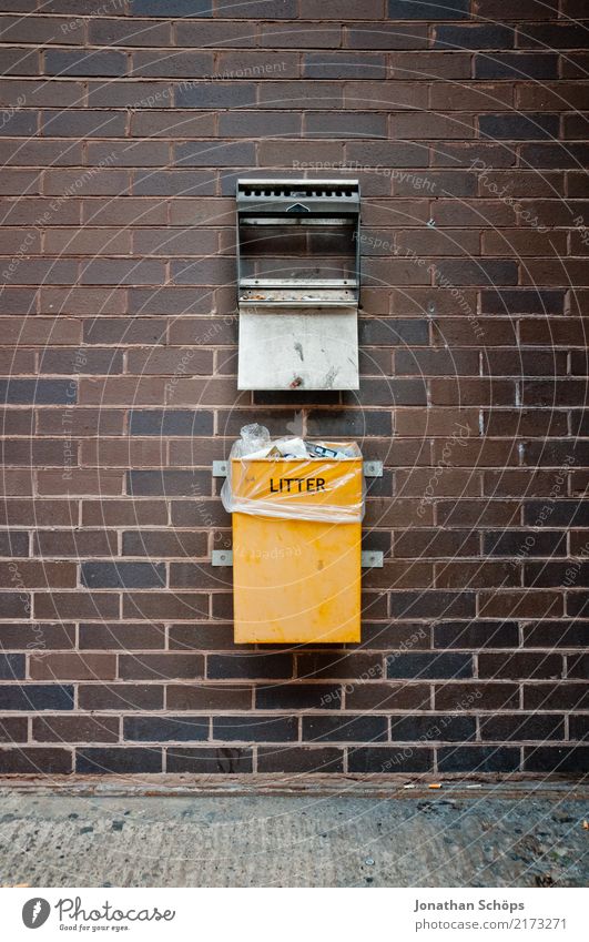 English garbage can on a wall Town Downtown Dirty Yellow Trash Trash container Dustman Refuse disposal Waste utilization Waste management Wall (building) Brick