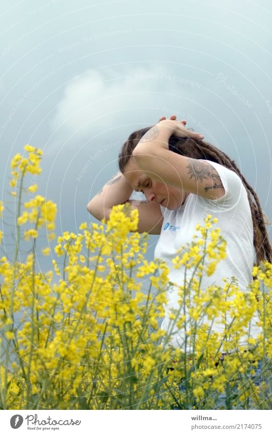 Young tattooed woman with Rastas in blooming rape Young woman Canola field Tattoo Youth (Young adults) Human being spring Oilseed rape flower Long-haired