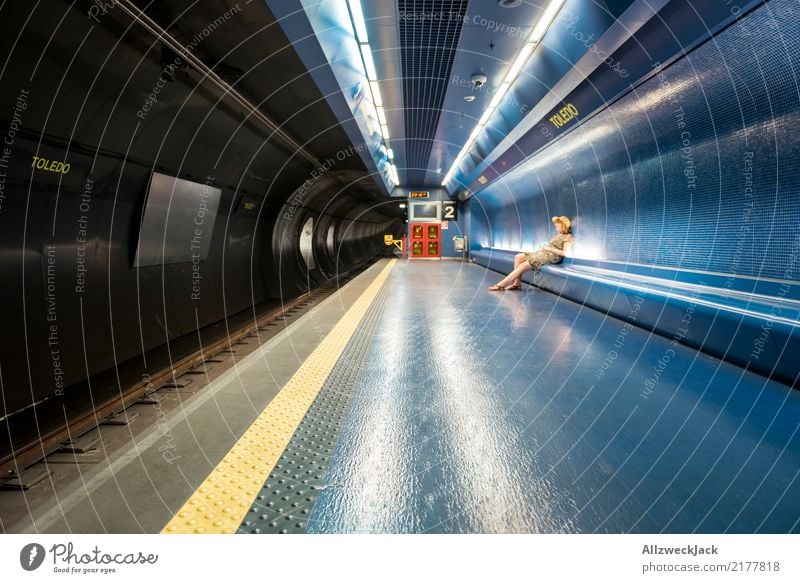 Woman sits in the subway and waits Feminine Sit Wait Hat Dress Underground Transport Public transit Tile Subsoil Railroad tracks Vacation & Travel