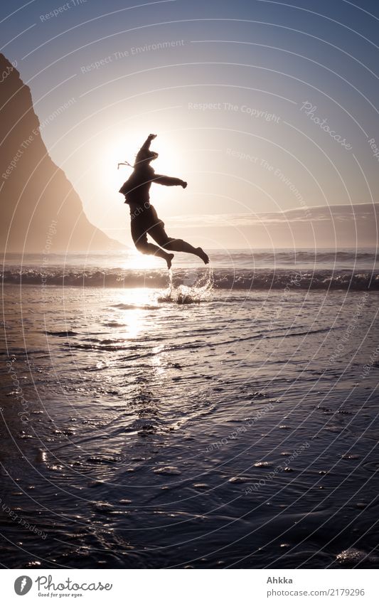 Young woman jumps out of the sea into the sunset Life Harmonious Contentment Senses Adventure Dance Youth (Young adults) Nature Cloudless sky Horizon Sun