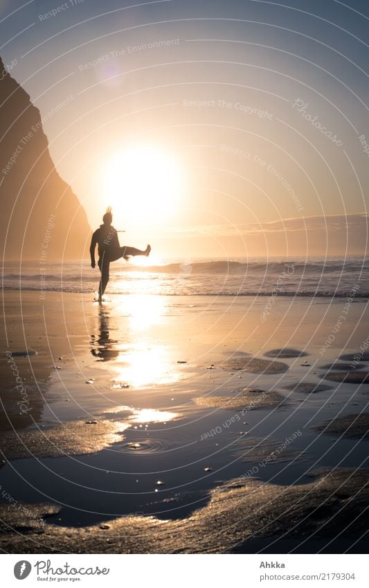 Sport activity of young person on beach in front of low sun in back light with mountains Athletic Fitness Life Harmonious Well-being Senses Meditation