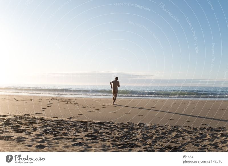 Naked man runs liberated on the empty beach towards the undulating sea Beach Man Running Longing Speed Freedom self-sufficient footprints Sand Ocean Target