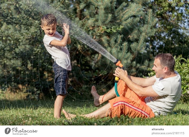 Happy father and son playing in the garden at the day time. People having fun oudoors. Concept of happy family. Lifestyle Joy Leisure and hobbies Playing