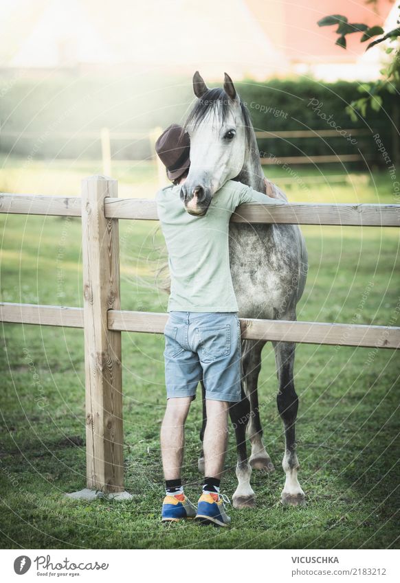 Young man hugs horse Lifestyle Human being Youth (Young adults) Nature Meadow Animal Horse Emotions Moody Pasture Fence Embrace Man Colour photo Exterior shot