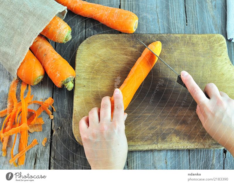 process of cutting fresh carrots Vegetable Nutrition Vegetarian diet Diet Juice Knives Body Table Arm Hand Nature Wood Fresh Natural Carrot background food