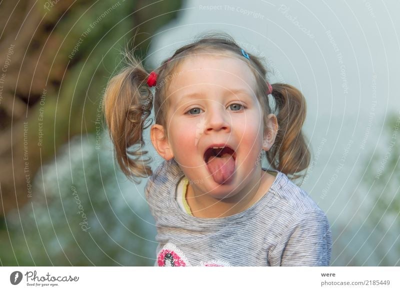 Little girl with blonde hair sticks out her tongue Playing Child Human being Feminine Toddler Head 1 3 - 8 years Infancy Brash Curiosity Cute Dirty Blonde