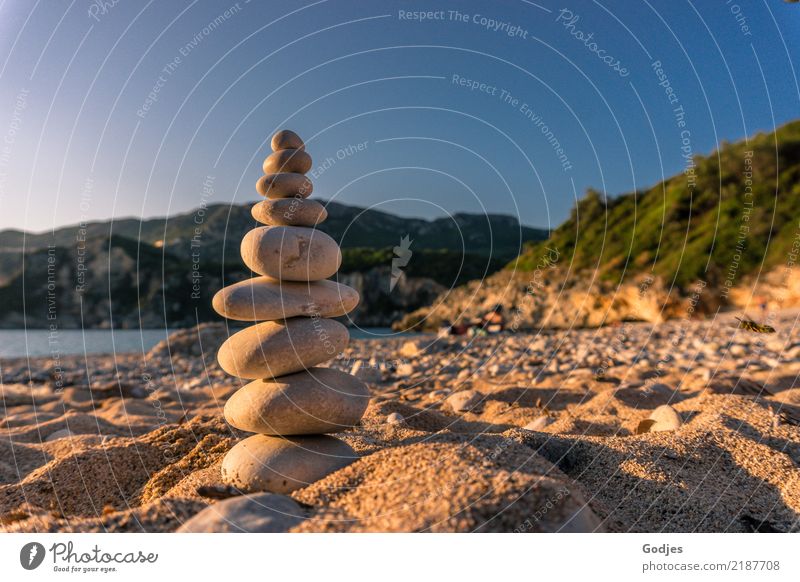 Stone pyramid on a sandy beach with mountains and water in the background Landscape Sand Water Cloudless sky Summer Beautiful weather Tree Bushes Beach Bay